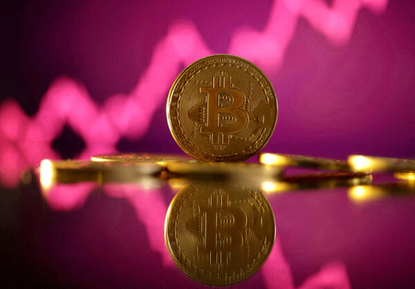 A representation of bitcoin is seen in front of a stock graph in this illustration. (Reuters)