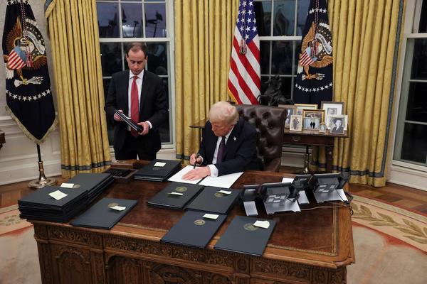 U.S. President Donald Trump signs documents as he issues executive orders and pardons for January 6 defendants in the Oval Office at the White House on Inauguration Day in Washington, U.S., January 20, 2025. (REUTERS)