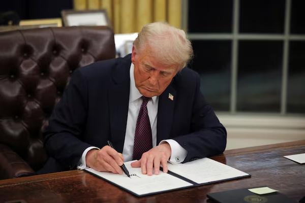 U.S. President Donald Trump signs documents as he issues executive orders and pardons for January 6 defendants in the Oval Office at the White House on Inauguration Day in Washington, U.S., Jan. 20, 2025. (REUTERS)