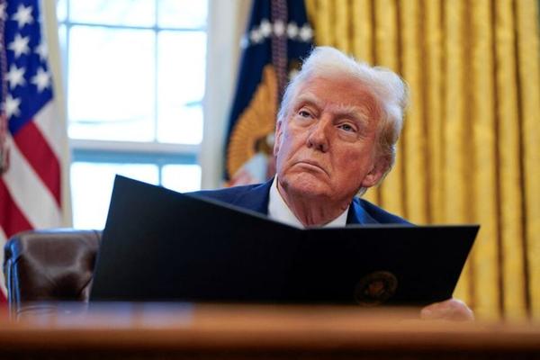 U.S. President Donald Trump signs executive orders in the Oval Office at the White House in Washington, U.S., January 30, 2025. REUTERS