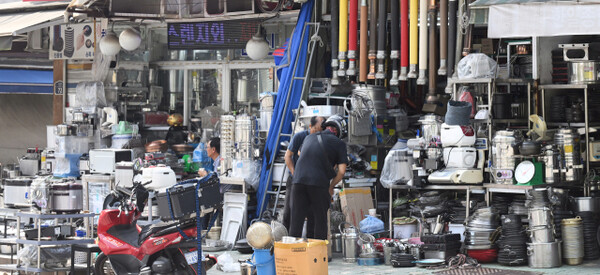 Piles of used kitchenware and equipment from shuttered restaurants fill the streets of Hwanghak-dong, Seoul.